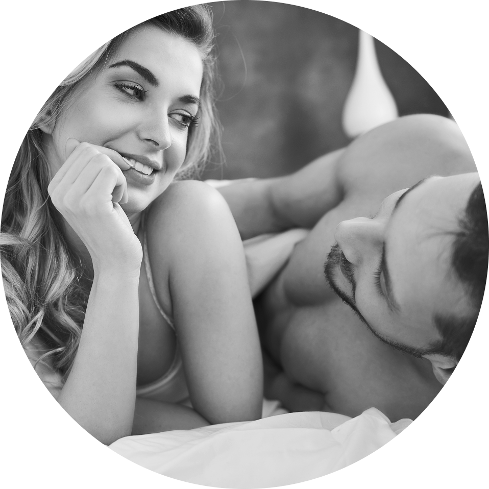 Happy middle-aged Caucasian couple smiling in bed, talking about their relationship