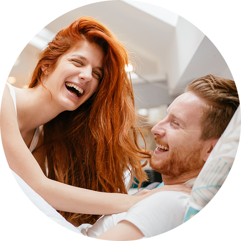 glückliches Pärchen spielt ein Spiel für Paare im Bett