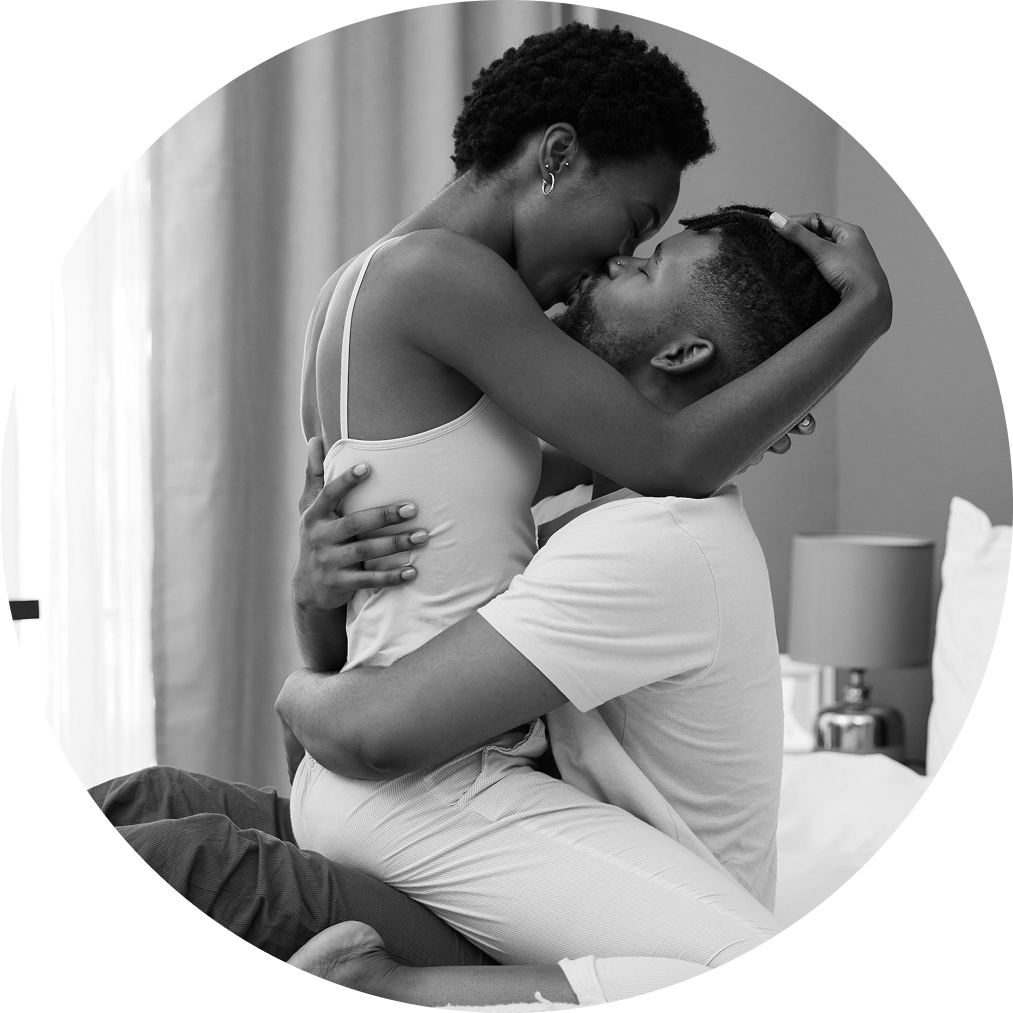 Mid-adult couple passionately kissing on bed, sharing a moment of intimacy and physical connection