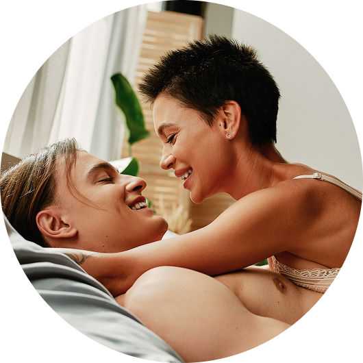 Lachendes glückliches Paar liegt im Bett, erotischer und sexy Vibe